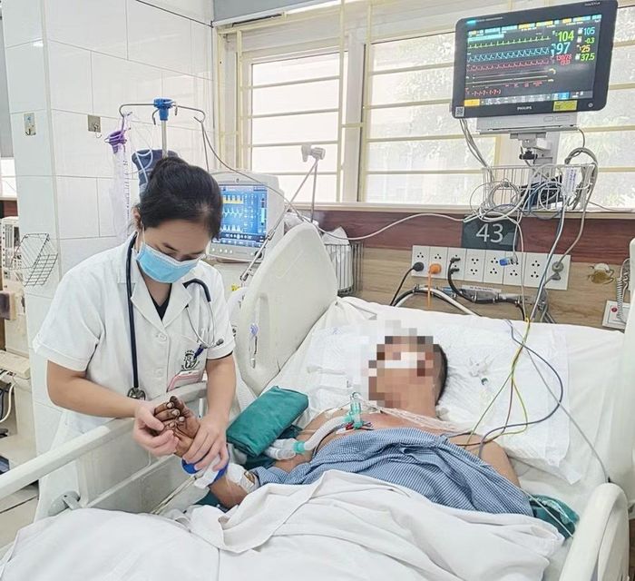 Người chồng đang được điều trị tích cực tại Trung tâm Chống độc, tay chân vẫn còn dính tàn dư của đám cháy. Ảnh: Nguyên Hà