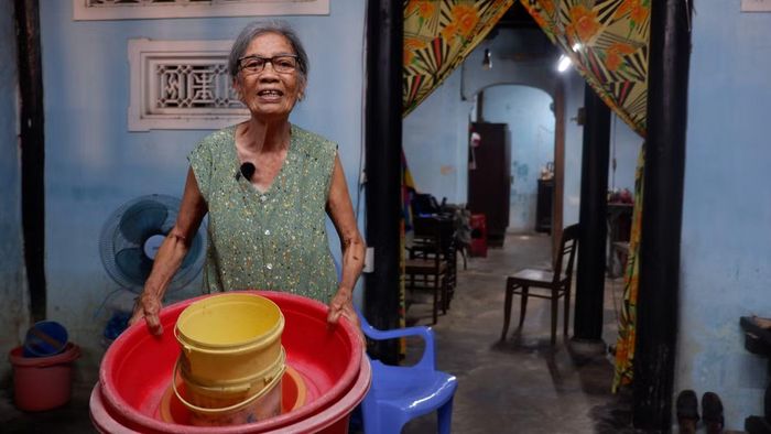 Bà Ngô Thị Gần chuẩn bị thau chậu hứng nước mưa trong nhà cổ