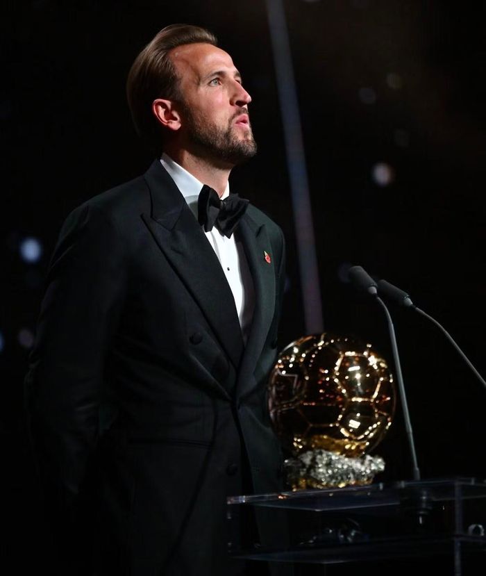  Bộ tuxedo đen tiếp tục đồng hành Kane trên sân khấu nhận giải. Tiền đạo Bayern Munich vượt qua những đối thủ hàng đầu như Kylian Mbappé và Lamine Yamal để giành Quả bóng vàng nam 2026. Trong đêm vinh danh sự nghiệp sân cỏ, lựa chọn trang phục tiết chế của Kane cũng phù hợp hình ảnh cầu thủ đề cao sự chuyên nghiệp, hơn là gây chú ý bằng vẻ ngoài khác biệt. Ảnh: AP. 