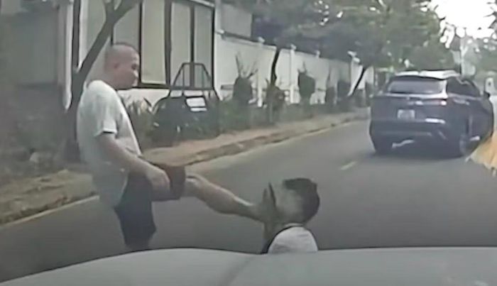 Người này sau đó đá thẳng vào mặt tài xế ô tô màu trắng, khiến anh này ngã gục xuống đường.