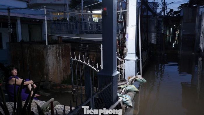 Người dân trên đường Rạch Cùng phải đắp bao cát để ngăn nước tràn vào nhà.