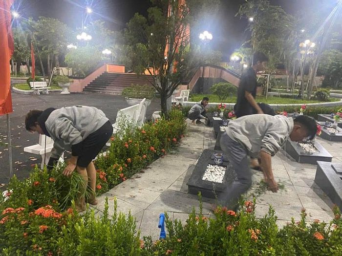 Các em đi từng phần mộ liệt sĩ để nhổ cỏ, lau dọn vệ sinh. Ảnh: CACC