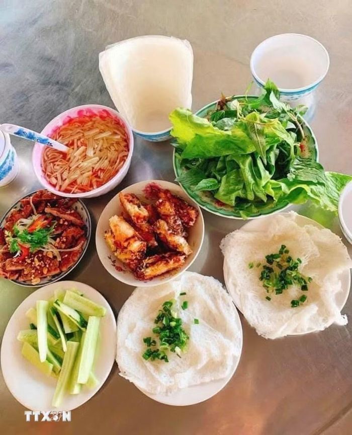 Bánh hỏi An Nhứt được ăn kèm với thịt nướng và chả giò. (Ảnh: Hoàng Nhị/TTXVN)
