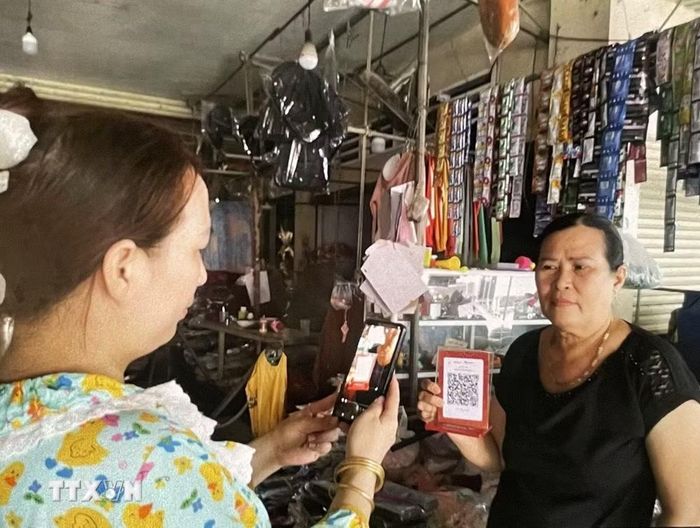 Người dân quét QR thanh toán mua nhu yếu phẩm. (Ảnh: Hồng Nhung/TTXVN)