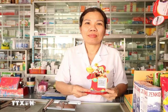 Mỗi tiểu thương đều liên kết với ngân hàng để thực hiện thanh toán không tiền mặt. (Ảnh: Hồng Nhung/TTXVN)
