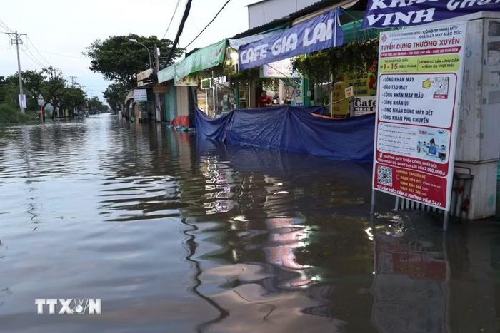 Đường Nguyễn Bình đoạn từ ngã tư Lê Văn Lương ngập sâu biến thành sông, kéo dài 2 km, hầu như rất ít phương tiện di chuyển qua đây. (Ảnh: Hồng Đạt/TTXVN)