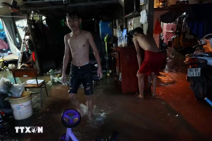 Nước ngập sâu do triều cường lên cao tràn vào nhà dân trên đường Nguyễn Bình, xã Hiệp Phước, chiều 27/10. (Ảnh: Hồng Đạt/TTXVN)