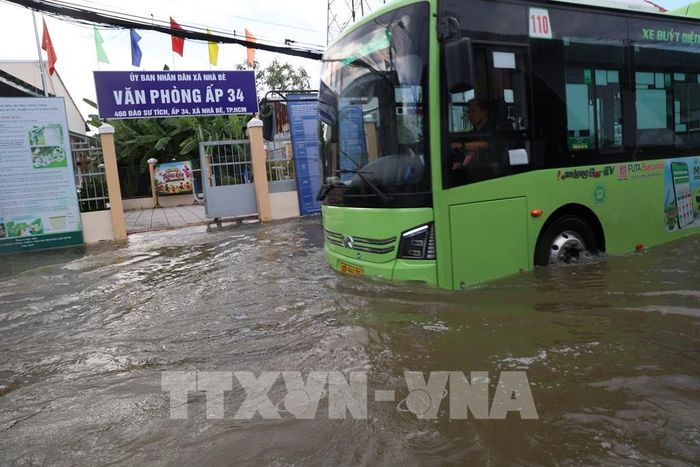 Các phương tiện di chuyển qua đoạn ngập sâu đường Đào Sư Tích, xã Nhà Bè, thời điểm 17 giờ chiều 27/10. Ảnh: Hồng Đạt - TTXVN