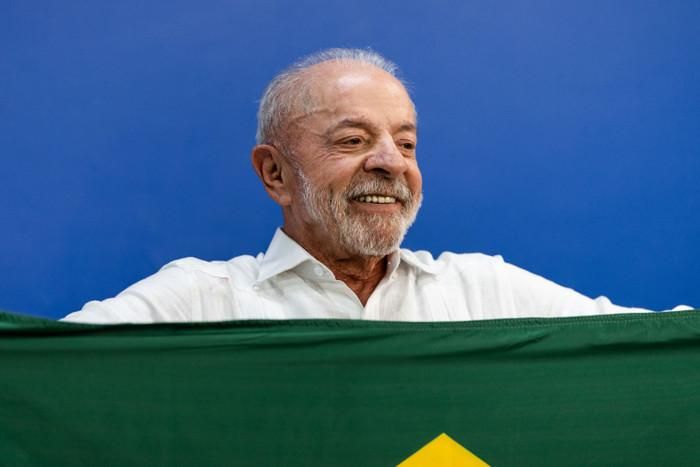 Tổng thống Brazil Luiz Inacio Lula da Silva cầm quốc kỳ Brazil khi bỏ phiếu tại một điểm bầu cử trong vòng bầu cử thứ hai ở Sao Bernardo do Campo, Brazil, hôm Chủ nhật, ngày 25 tháng 10. Hình ảnh Maira Erlich/Bloomberg/Getty