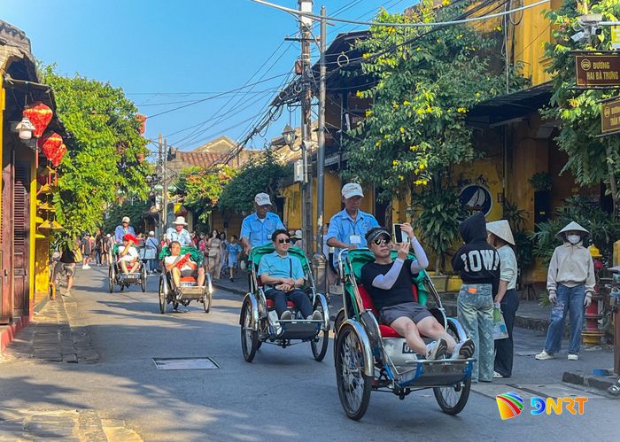 Du khách tham quan phố cổ bằng xích lô. Ảnh: XUÂN SƠN