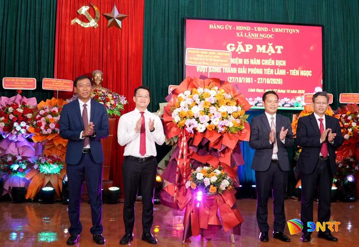 Lãnh đạo Ban Tuyên giáo Thành ủy (thứ 2, trái sang) tặng hoa chúc mừng địa phương dịp gặp mặt kỷ niệm 65 năm Chiến dịch Vượt sông Tranh giải phóng Tiên Lãnh - Tiên Ngọc. Ảnh: HỒ QUÂN