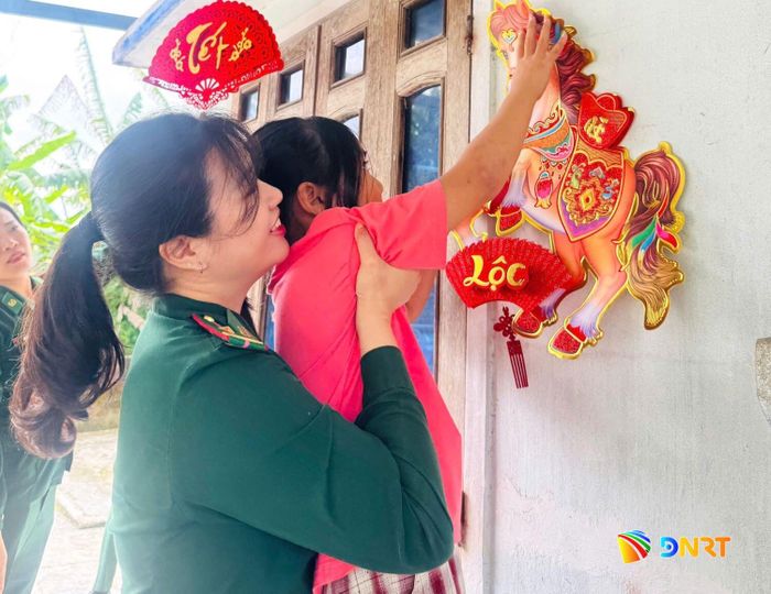 Thiếu tá quân nhân chuyên nghiệp Đinh Thị Vân Trang cùng các con nuôi trang trí nhà cửa đón Tết. Ảnh: HOÀ BÌNH