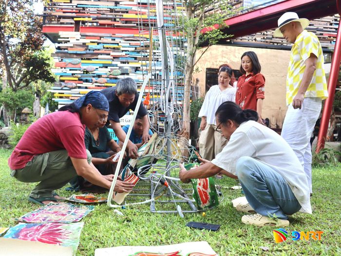 Thực hành dán các tác phẩm lên đèn lồng. Ảnh: QUỐC TUẤN