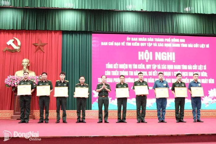 Đại tá Bùi Khánh Hòa, Phó Chỉ huy trưởng Bộ Chỉ huy Quân sự thành phố trao giấy khen cho các cá nhân. Ảnh: Nguyệt Hà