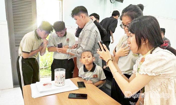 Gia Hân (bìa phải) cùng các thành viên trong nhóm hướng dẫn học sinh Trường Khuyết tật Nhân Ái sử dụng “Thanh Âm”.