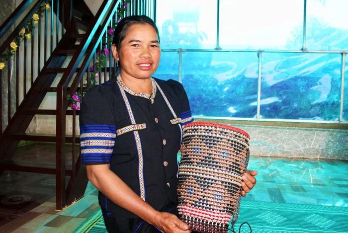 Chị Rơ Châm H’yun sử dụng chốt bật từ lon bia, nước ngọt để trang trí gùi. Ảnh: Minh Chí 
