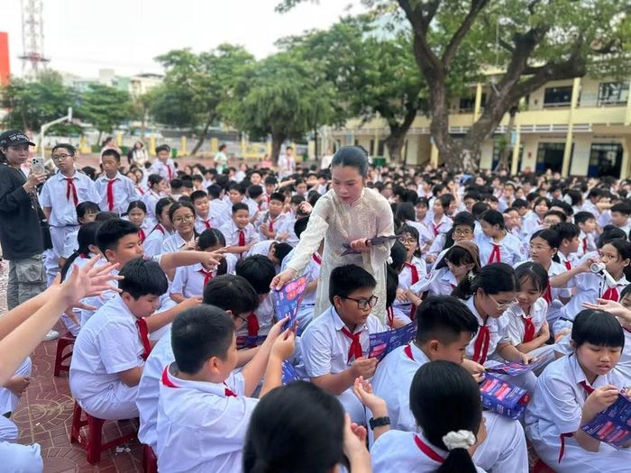 KOL Bùi Thị Mỹ Dân phát cẩm nang “Kết nối không tổn thương” cho học sinh Trường THCS Lê Hồng Phong (phường Quy Nhơn). Ảnh: Kiều Anh