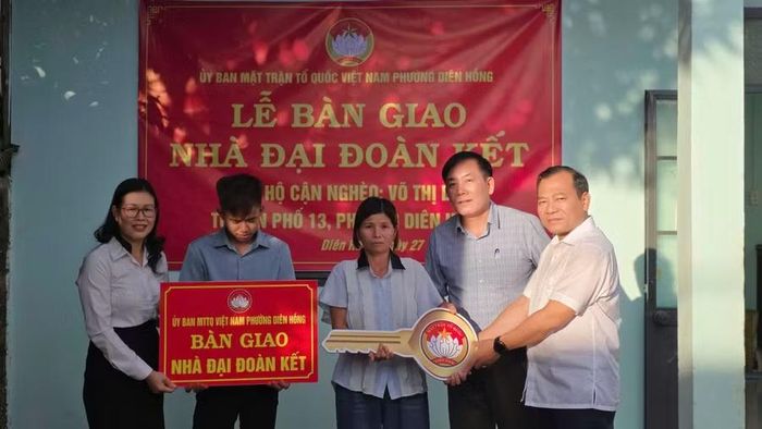 Đại diện lãnh đạo địa phương và các đơn vị trao nhà "Đại đoàn kết" cho gia đình bà Lan. Ảnh: Bá Bính