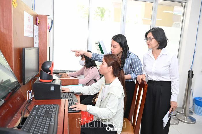 Thành viên đoàn kiểm tra công tác cải cách hành chính tỉnh (bìa phải) kiểm tra việc hướng dẫn người dân tại phường Nha Trang.