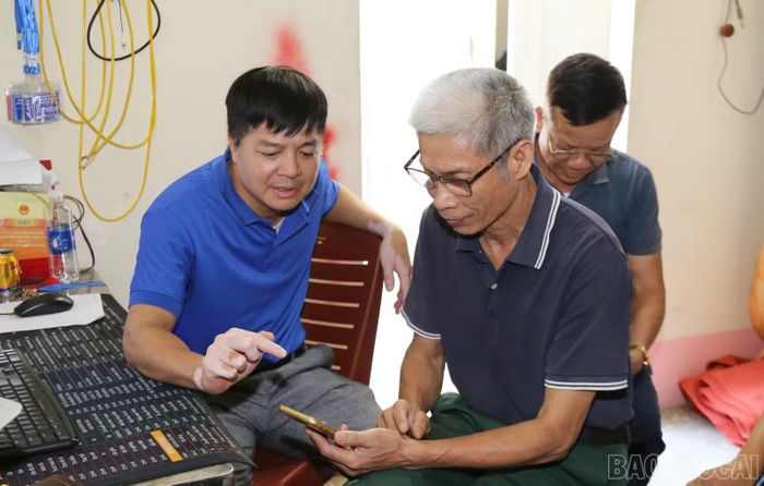 Đảng viên Trần Quốc Toản hướng dẫn người dân thực hiện thủ tục hành chính trực tuyến.