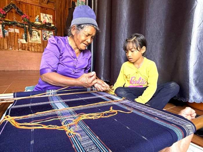 Bà Bon Niêng Ka Lang, thôn Đưng K'nớ hướng dẫn cháu dệt thổ cẩm truyền thống