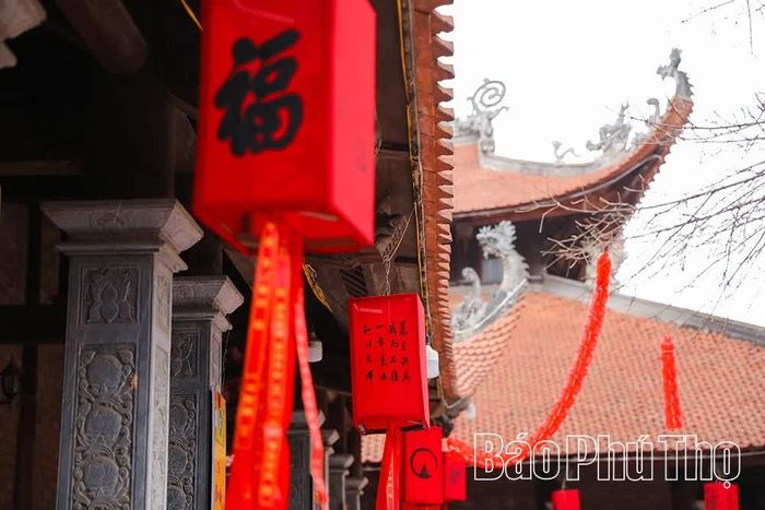 Những dải lụa cầu an và đèn lồng đỏ nổi bật dọc hành lang chùa, hòa cùng sắc cờ Phật giáo, gợi lên những ước nguyện tốt lành của người hành hương.