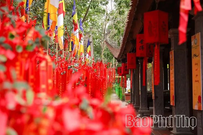Những dải cờ Phật giáo nhiều màu sắc trải dài trước mái chùa đỏ thắm, điểm tô nét rực rỡ cho không gian kiến trúc truyền thống vốn trầm mặc, tĩnh lặng.