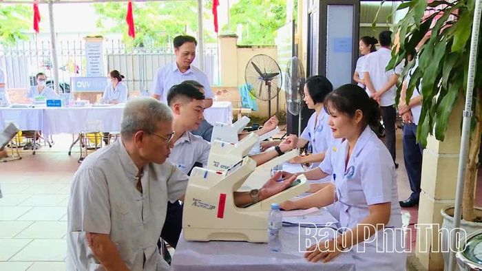Cán bộ y tế đo huyết áp cho người dân bằng thiết bị tự động tại Trạm Y tế phường Vĩnh Phúc.