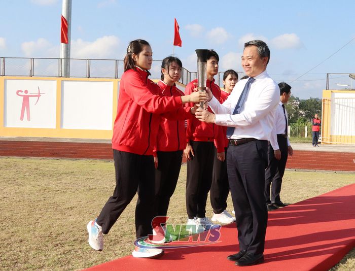 Đồng chí Chủ tịch UBND tỉnh nhận đuốc truyền thống từ đoàn rước đuốc.