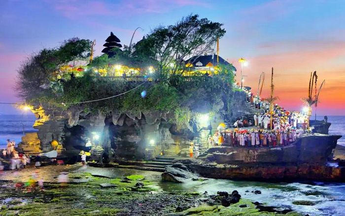 Đền Tanah Lot nằm trên một mỏm đá nhô ra biển, được bao quanh bởi làn nước biển trong xanh. Không chỉ là điểm đến của các tín đồ Hindu giáo, mà đền Tanah Lot đã trở thành một trong những điểm du lịch ấn tượng ở Bali, Indonesia. Ảnh: expedia