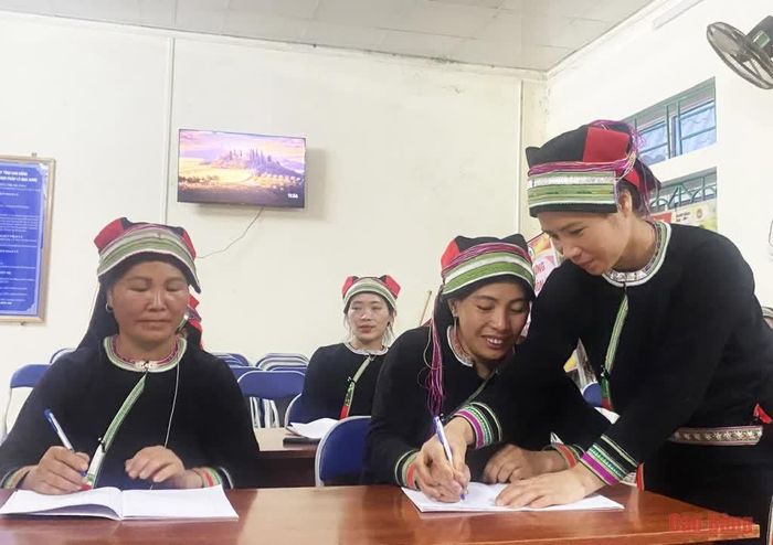 Chị Triệu Thị Xỉm kiên nhẫn giúp chị em trong từng nét chữ.