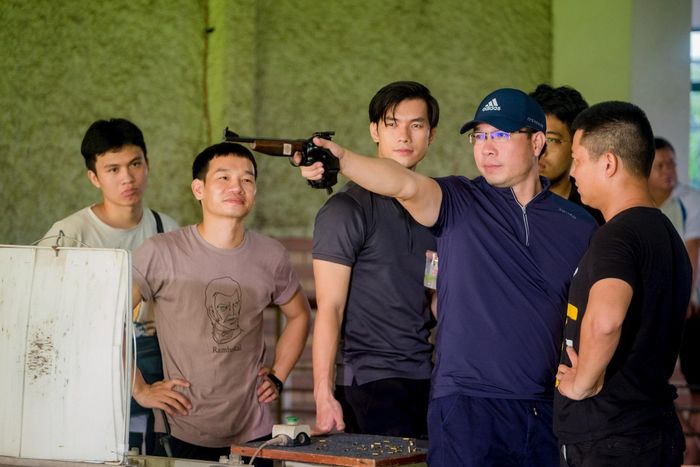 Xạ thủ Hoàng Xuân Vinh hướng dẫn diễn viên kỹ thuật bắn súng. Ảnh: BC Pictures