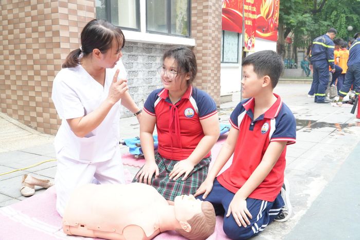 Cán bộ y tế hướng dẫn học sinh thực hành kỹ năng sơ cấp cứu. Ảnh: Tùng Lâm