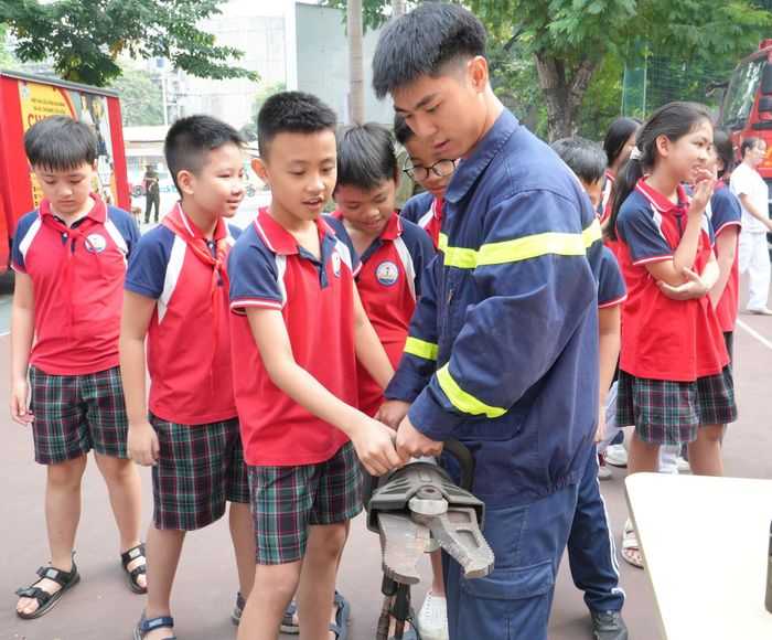 Cán bộ hướng dẫn học sinh sử dụng kìm cộng lực. Ảnh: Tùng Lâm