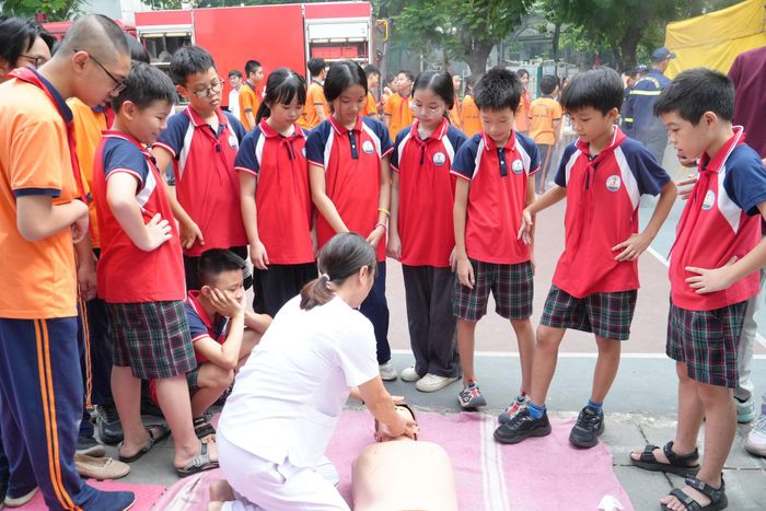 Cán bộ y tế hướng dẫn học sinh thực hành kỹ năng sơ cấp cứu. Ảnh: Tùng Lâm