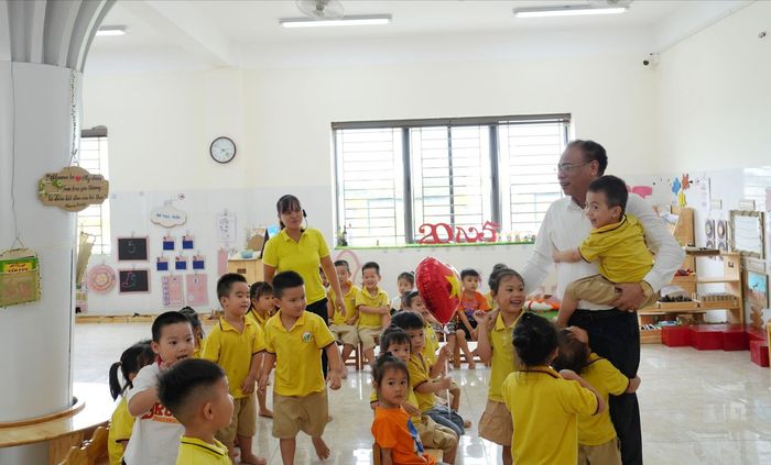 Bí thư Đảng ủy, Chủ tịch HĐND xã Đan Phượng Nguyễn Gia Hiển cùng các em học sinh trên địa bàn. Ảnh: Thiên Tú