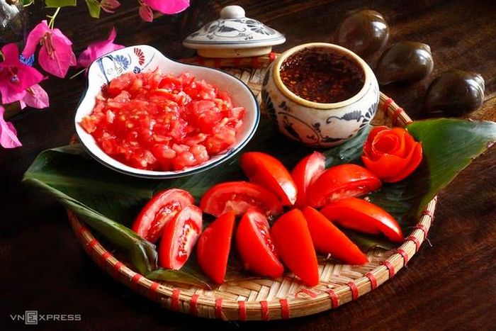 Chuẩn bị cà chua tạo màu: Cà chua chia làm hai phần: Một phần băm nhỏ để xào tạo màu hồng nhạt cho nước dùng, một phần bổ múi cau.