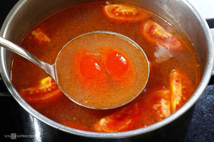 Nấu nước dùng: Nếu thích hương vị mộc nguyên bản thuần vị ốc, chỉ dùng nước luộc ốc nhồi và nước luộc ốc vặn lắng lọc sạch. Nếu muốn tăng thêm độ ngọt tự nhiên và làm mềm vị thêm nước ninh xương hom ninh 3 - 4 giờ, mở vung rồi lọc lấy nước. Hòa chung nước luộc ốc và nước ninh xương. Phi thơm hành khô và đầu hành trắng với mỡ lợn, cho phần cà chua băm nhỏ vào xào mềm rồi lọc qua rây cho vào nồi nước dùng tạo màu hồng nhạt. Thả phần cà chua bổ múi cau vào đun vài phút, nêm nếm gia vị cho vừa miệng rồi từ từ xuống giấm bỗng cuối cùng tạo vị chua dịu và lưu hương thơm cho nước dùng.