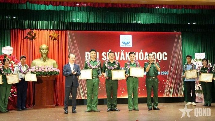  Trung tá Nguyễn Hữu Hưng (đứng giữa) nhận danh hiệu Đại sứ Văn hóa đọc. 