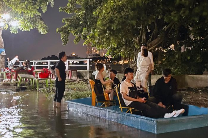 Nhân viên phải lội nước, dùng thuyền tự chế đưa khách vào nhà hàng, ảnh chụp lúc 17h30-18h, ngày 27/10.