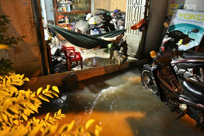  Hộ dân trong hẻm 85 dùng thanh gỗ chắn ở cửa ra vào để ngăn nước tràn vào nhà. 