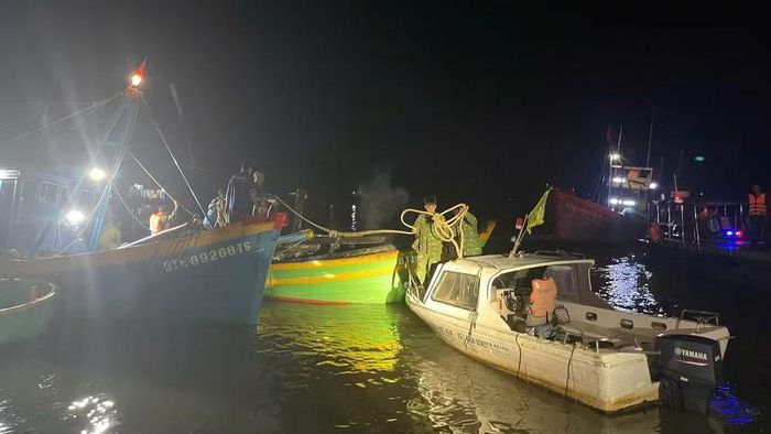 Các lực lượng biên phòng đang lai dắt tàu cá vào bờ. (Ảnh: Bộ đội Biên phòng cung cấp)