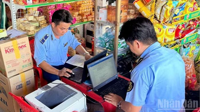 Lực lượng Quản lý thị trường Tây Ninh lập biên bản hộ kinh doanh thuốc lá nhập lậu không xuất trình được hóa đơn, chứng từ hay bất kỳ giấy tờ liên quan. (Ảnh: THANH PHONG)