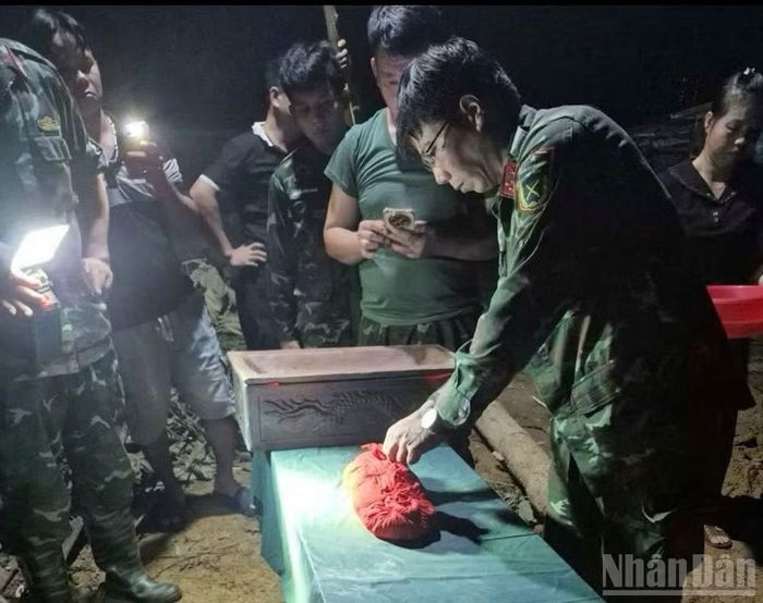 Lực lượng chức năng tiến hành khai quật, cất bốc hài cốt liệt sĩ. (Ảnh: HỮU ĐỨC)
