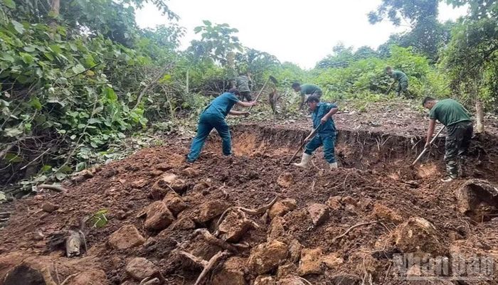 Lực lượng tìm kiếm tiến hành khai quật mộ liệt sĩ. (Ảnh: THANH SƠN)
