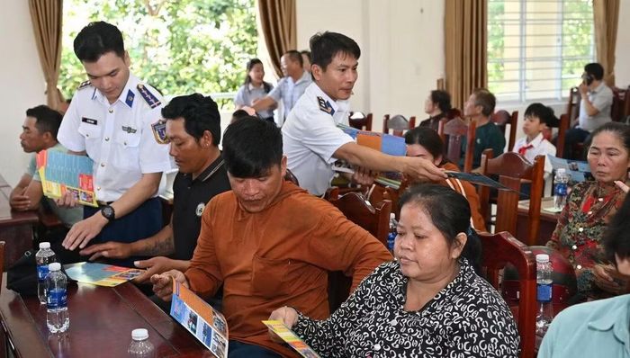 Cảnh sát biển phát tờ rơi tuyên truyền phòng, chống IUU cho ngư dân Long Hải. (Ảnh: Cảnh sát biển cung cấp)