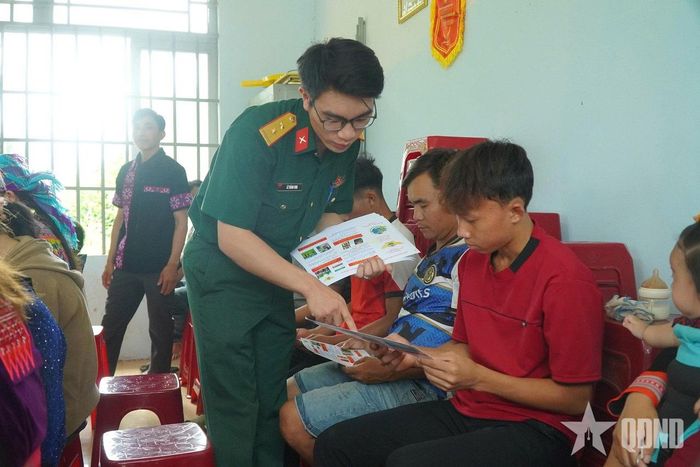   Cán bộ Đoàn Kinh tế - Quốc phòng 720 phát tờ rơi tuyên truyền pháp luật đến bà con. 