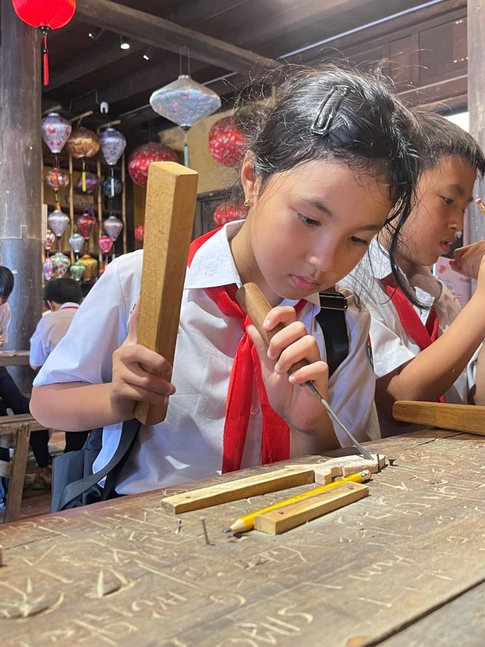 Các em trải nghiệm làm sản phẩm mộc tại Bảo tàng Văn hóa Dân gian Hội An.