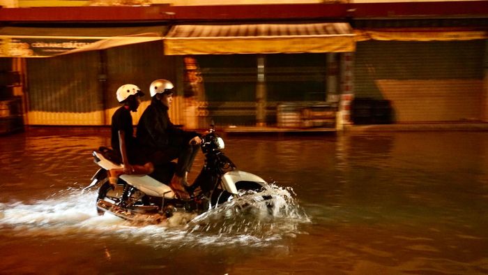 Đường Đoàn Trần Nghiệp, phường Thủ Dầu Một ngập sâu 30-40cm gây khó khăn cho phương tiện qua lại. Ảnh: DUY TRẦN