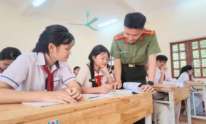 Trung úy Trung tận tình chỉ dạy từng bài toán cho các em. Ảnh: Thùy Dương
